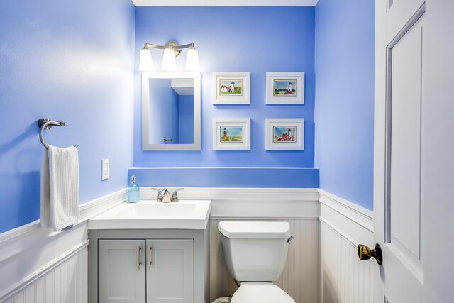 46 Juniper Ln W, South Chatham, MA 02659 - half bathroom with vanity, a decorative wall, a wainscoted wall, and toilet
