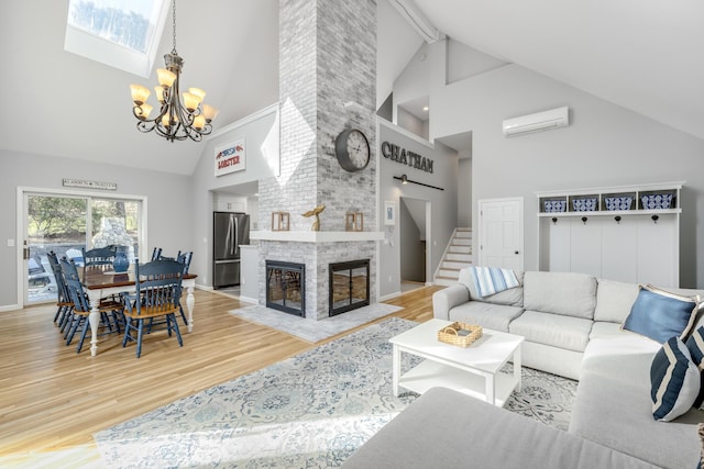 46 Juniper Ln W, South Chatham, MA 02659 - living room with high vaulted ceiling, an AC wall unit, wood finished floors, and a notable chandelier