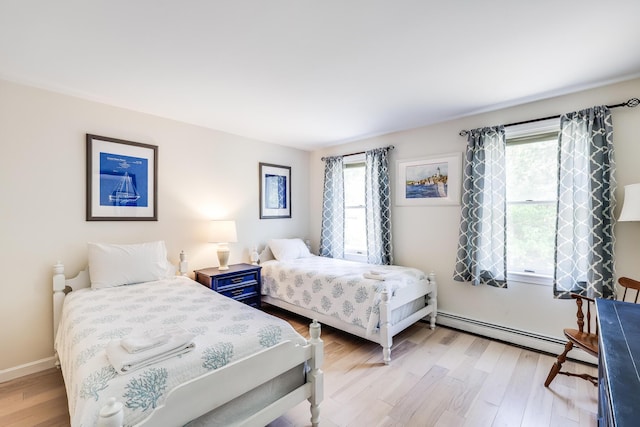 46 Juniper Ln W, South Chatham, MA 02659 - bedroom with baseboards, multiple windows, a baseboard heating unit, and light wood finished floors
