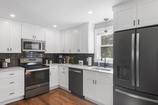 29 Braeburn Ct, Hatchville, MA 02536 - kitchen featuring appliances with stainless steel finishes, a sink, backsplash, white cabinetry, and dark wood finished floors