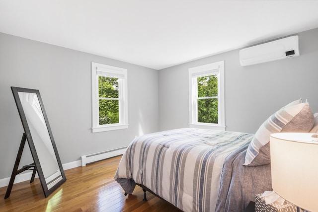 29 Braeburn Ct, Hatchville, MA 02536 - bedroom with a wall mounted air conditioner, a baseboard radiator, multiple windows, and hardwood / wood-style floors