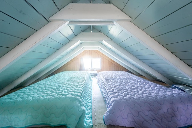 bedroom with wood ceiling, wood walls, and vaulted ceiling with beams