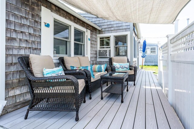 wooden terrace with an outdoor living space