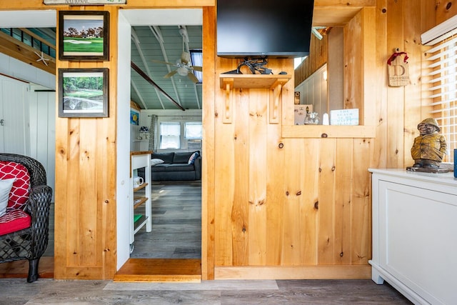 interior space with wooden ceiling, vaulted ceiling with beams, dark hardwood / wood-style floors, and wooden walls