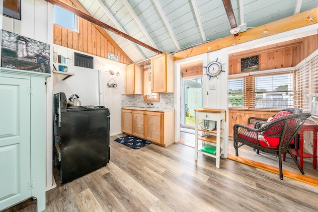 kitchen featuring light hardwood / wood-style flooring, light brown cabinetry, sink, backsplash, and beamed ceiling