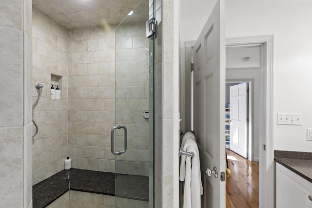 bathroom featuring a stall shower, vanity, and wood finished floors