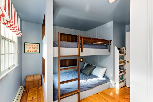 bedroom featuring baseboard heating and wood finished floors