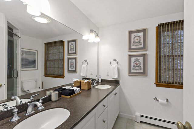 bathroom with a sink, a shower stall, toilet, and a baseboard radiator