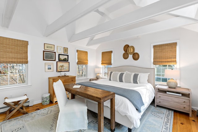 bedroom with beam ceiling, a baseboard heating unit, light wood-type flooring, and baseboards