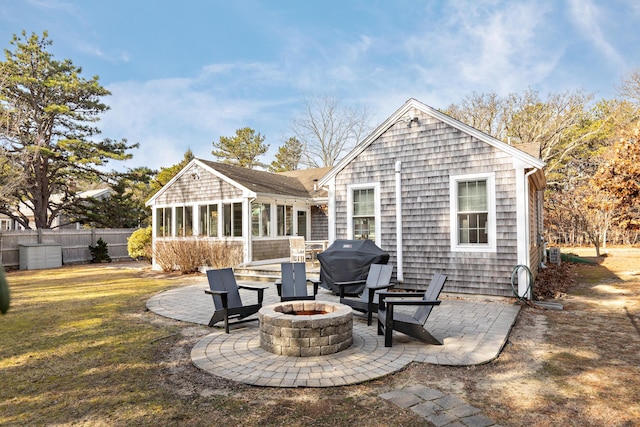 back of property with a patio area, fence, a sunroom, and an outdoor fire pit