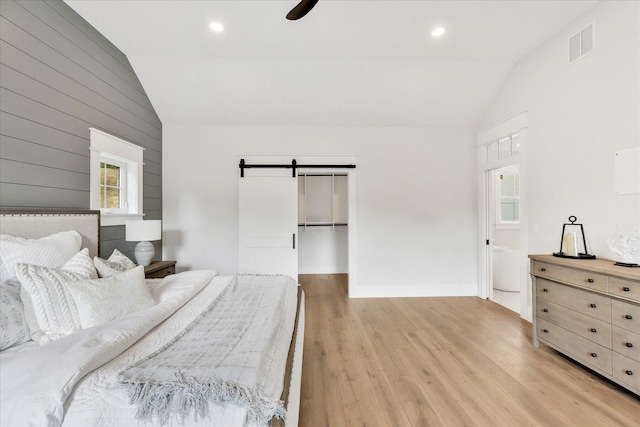 22 Country Club Ln, Mashpee, MA 02649 - bedroom featuring a barn door, a walk in closet, light wood-style floors, lofted ceiling, and visible vents