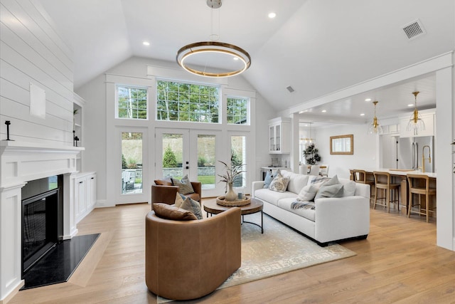 22 Country Club Ln, Mashpee, MA 02649 - living room featuring a glass covered fireplace, light wood-style flooring, visible vents, and high vaulted ceiling