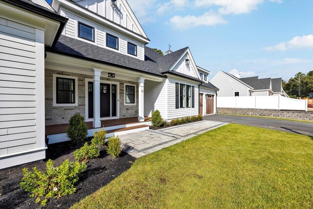 22 Country Club Ln, Mashpee, MA 02649 - view of front of house featuring roof with shingles, a front lawn, a porch, fence, and board and batten siding