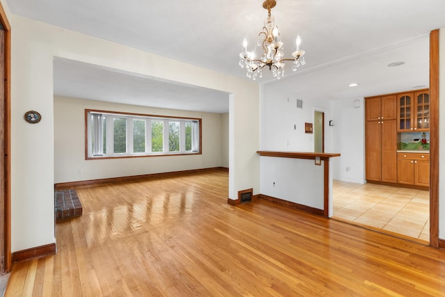 88 Hilltop St, Milton, MA 02186 - unfurnished living room with light wood finished floors, baseboards, and a chandelier