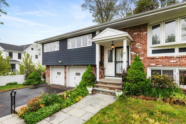 88 Hilltop St, Milton, MA 02186 - view of front of house with brick siding, driveway, and an attached garage