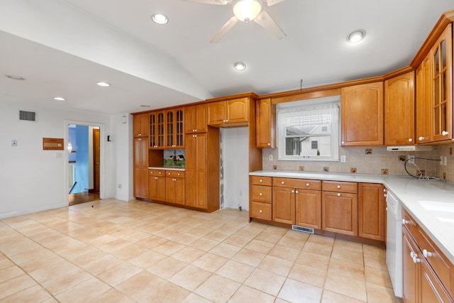 88 Hilltop St, Milton, MA 02186 - kitchen with tasteful backsplash, brown cabinetry, glass insert cabinets, light countertops, and lofted ceiling