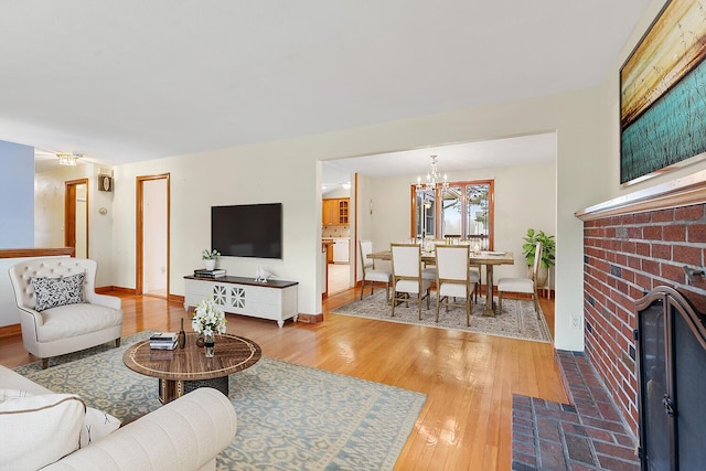 88 Hilltop St, Milton, MA 02186 - living area featuring a chandelier, wood finished floors, a brick fireplace, and baseboards