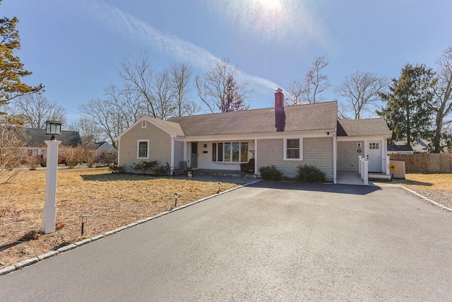 single story home featuring roof with shingles, fence, driveway, and a chimney