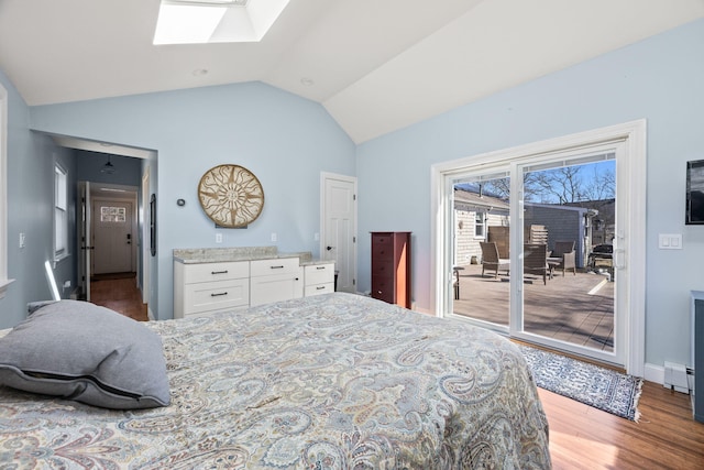 bedroom featuring a baseboard heating unit, access to exterior, wood finished floors, and lofted ceiling with skylight