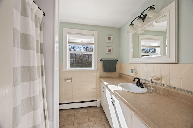 bathroom with tile walls, a baseboard heating unit, wainscoting, tile patterned floors, and vanity