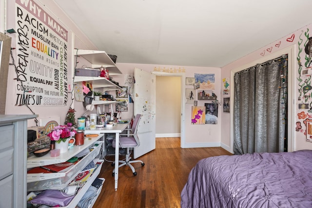 bedroom with wood finished floors and baseboards