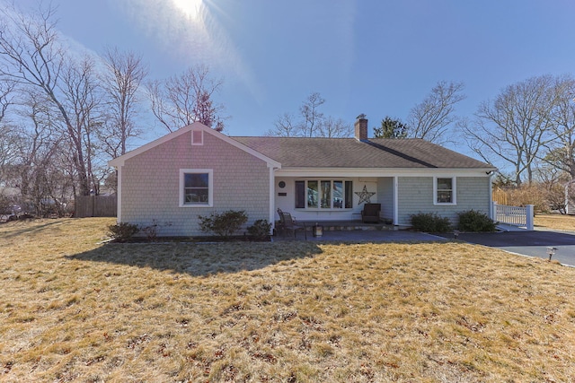 single story home featuring a chimney, a front lawn, and fence