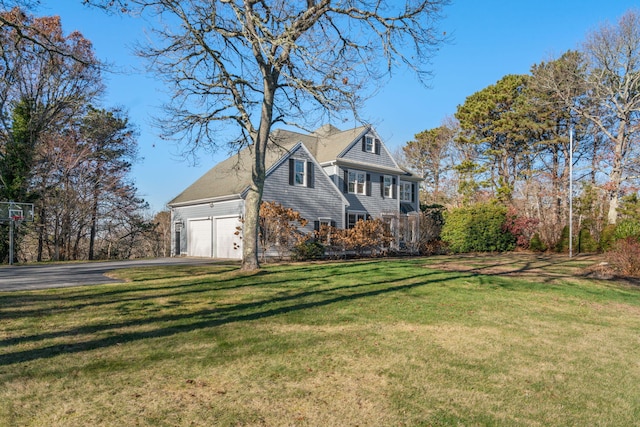 view of side of property with a lawn and a garage