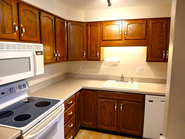 2 Englewood Dr Unit B-6, Harwich, MA 02645 - kitchen featuring white appliances, a sink, light countertops, and brown cabinetry
