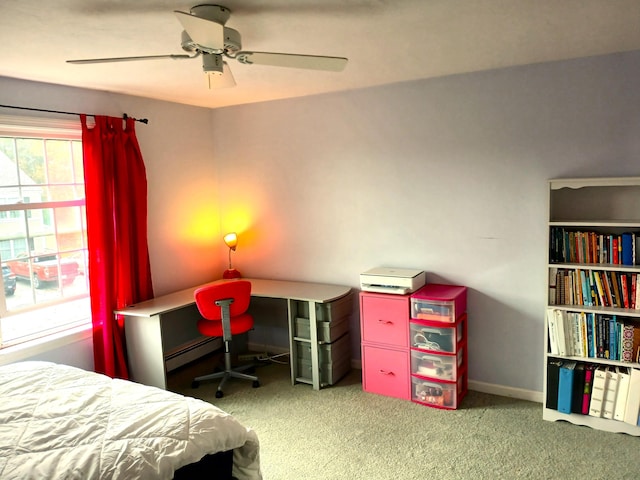 carpeted bedroom with ceiling fan and a baseboard heating unit