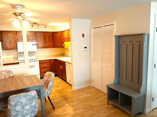 kitchen featuring light wood-type flooring, ceiling fan, white appliances, and sink