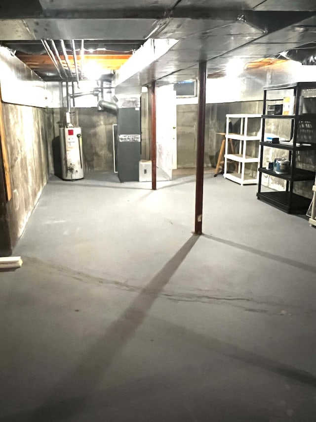 basement featuring water heater and heating unit