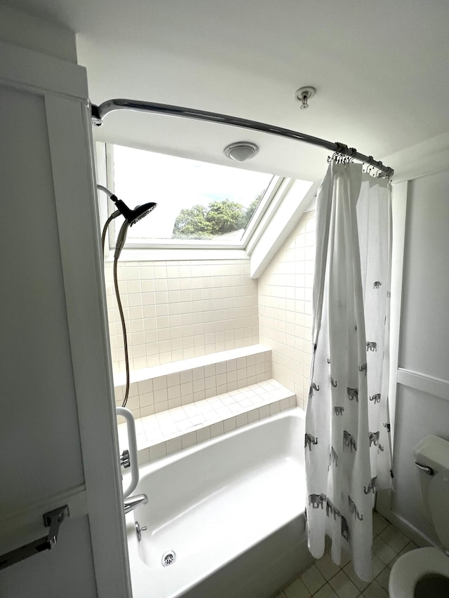 bathroom featuring a skylight, toilet, tile patterned floors, and shower / bathtub combination with curtain