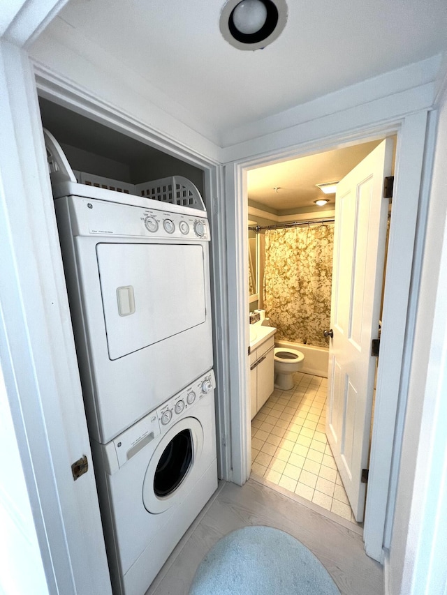 washroom featuring light tile patterned floors and stacked washer and clothes dryer