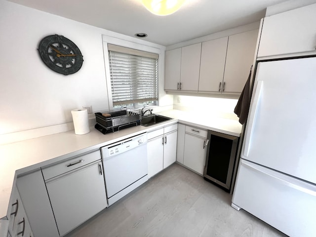 kitchen with sink, white cabinetry, and white appliances