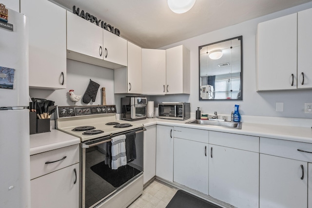 kitchen featuring a sink, visible vents, white appliances, and light countertops