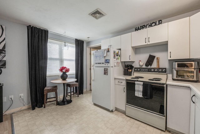 kitchen with electric range, light floors, light countertops, and freestanding refrigerator