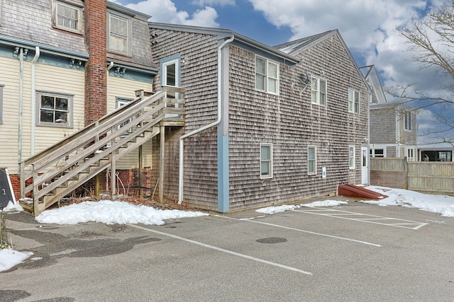 exterior space with fence, stairs, and uncovered parking