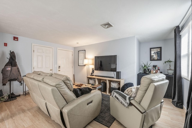 living area with light wood-style flooring and visible vents