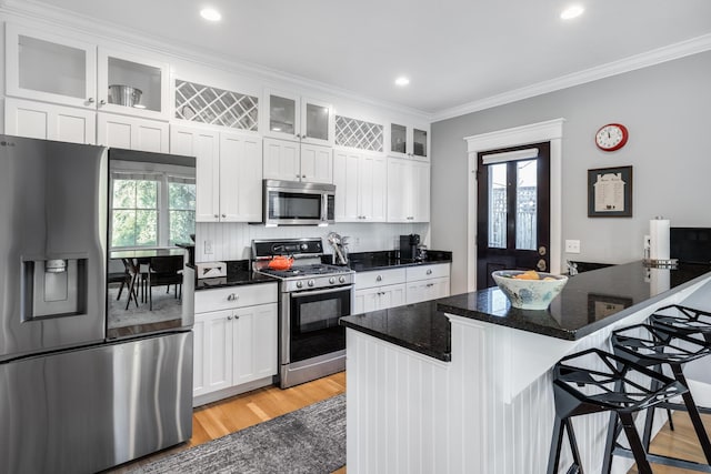 480 Main St Unit 1U, Falmouth, MA 02540 - kitchen with white cabinetry, stainless steel appliances, a kitchen breakfast bar, and ornamental molding