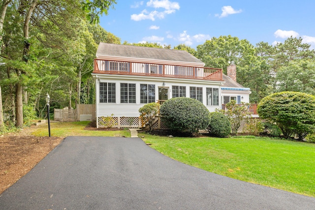 view of front of property with a balcony and a front lawn