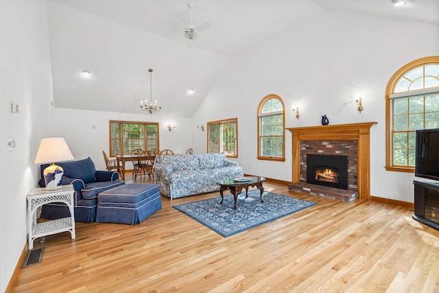 living room with a brick fireplace, light hardwood / wood-style flooring, and a wealth of natural light