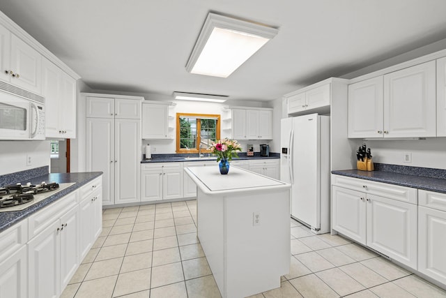 kitchen featuring a kitchen island, white cabinetry, white appliances, and light tile patterned floors