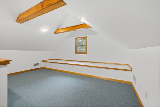 additional living space featuring lofted ceiling with beams and carpet floors