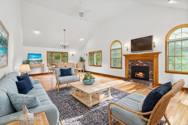 living room with a wealth of natural light, light hardwood / wood-style floors, and high vaulted ceiling