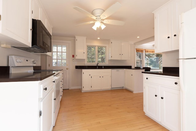 kitchen featuring dark countertops, white appliances, white cabinetry, and a ceiling fan