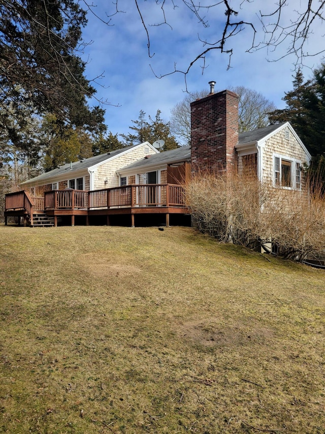 back of property featuring a lawn, a chimney, and a deck