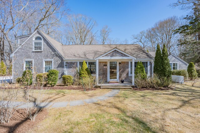 view of front of house with a front lawn and a shingled roof