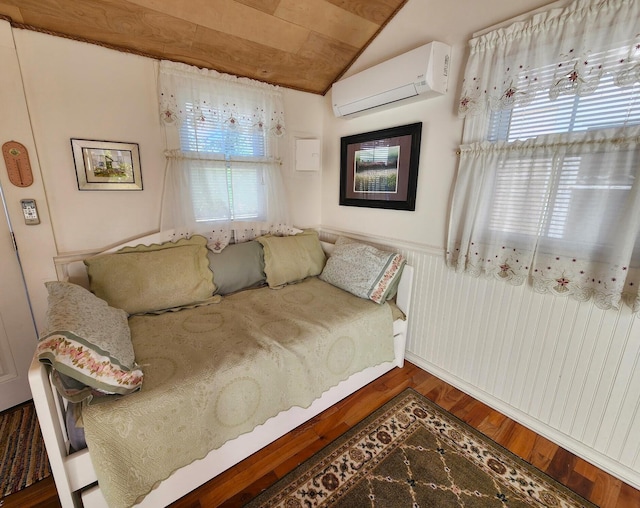 bedroom with multiple windows, wood-type flooring, lofted ceiling, and a wall unit AC