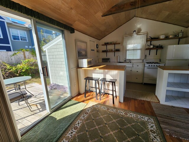 kitchen featuring white appliances, light hardwood / wood-style floors, wood ceiling, wooden counters, and sink