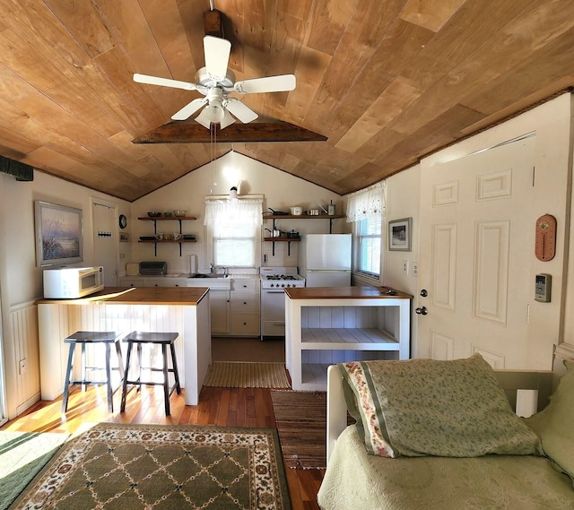 kitchen with wood ceiling, hardwood / wood-style flooring, white appliances, and a breakfast bar area